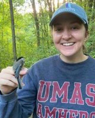 Isobel Smith holding small bird on finger in the woods